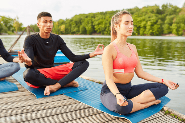 A lady and a man meditating.