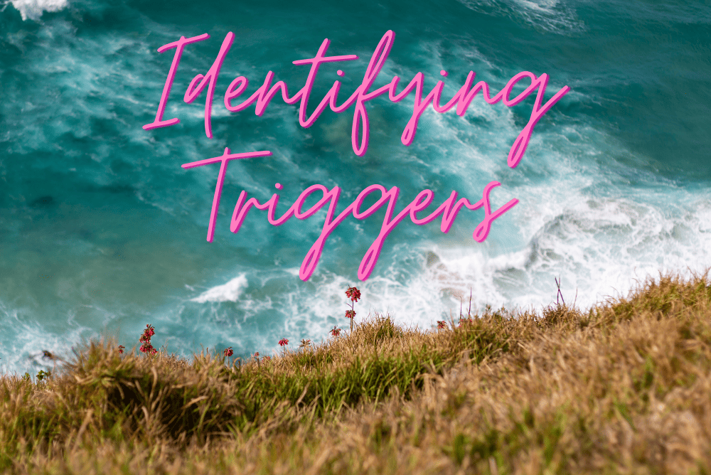 Identifying triggers written on picture of ocean beneath a hill.