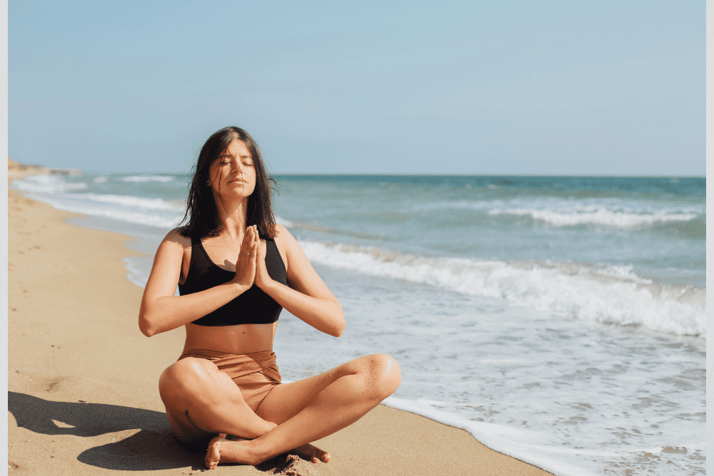 A lady practicing mindfulness at a beach