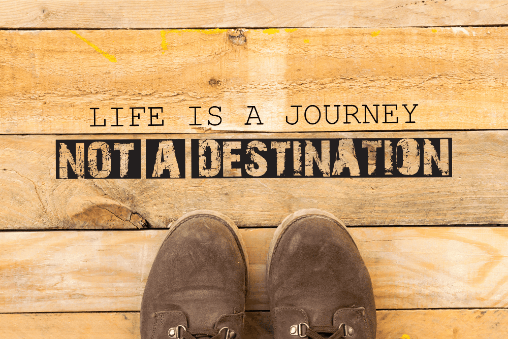 ''Life is a journey, not a destination'' written on a wooden board.