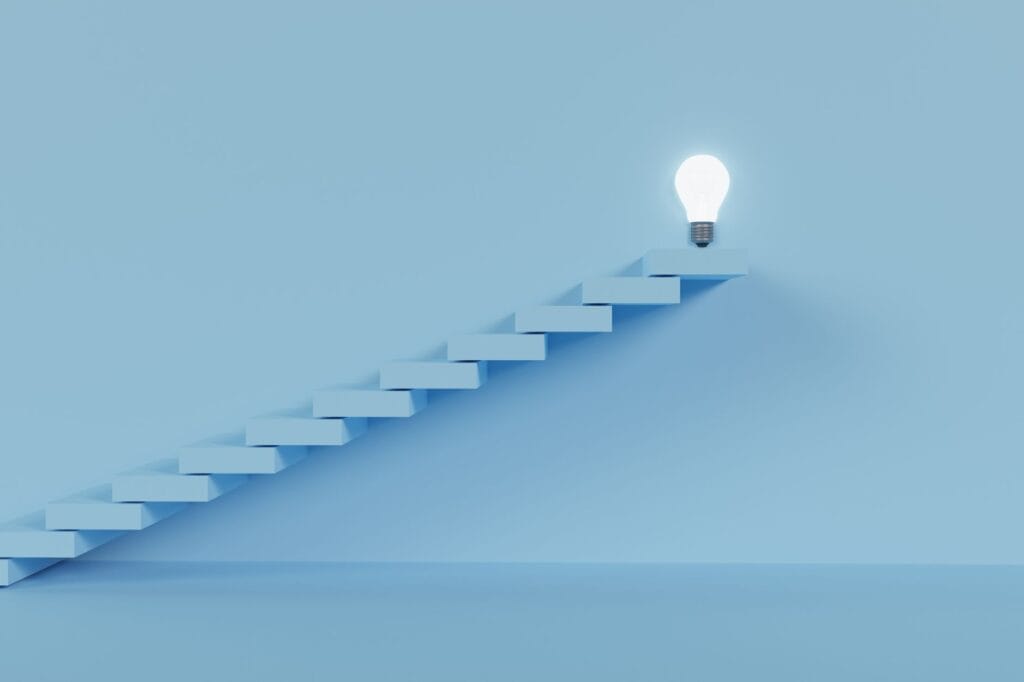 A staircase leads to a glowing light bulb at the top, symbolizing the journey toward financial stability, set against a light blue background.